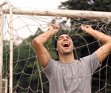 Man laughing in football net