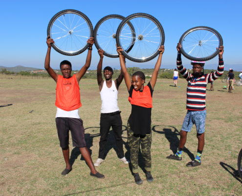 students holding up bike wheels