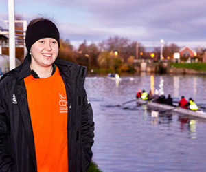 Woman smiling with rowing team in background