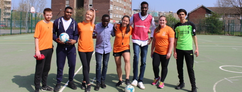 volunteers with refugees as part of the football and language refugee programme - posing for a photo