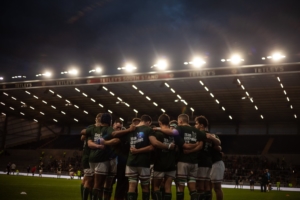 Uni of leeds men's rugby union team in a group huddle at headingley stadium for the leeds varsity 2019 finale match.