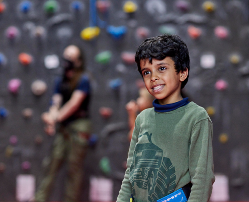 Child smiling near climbing wall