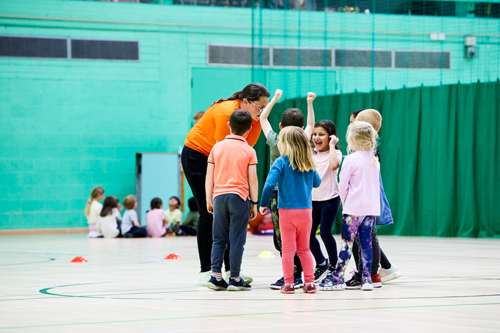 Leader with children on indoor pitch