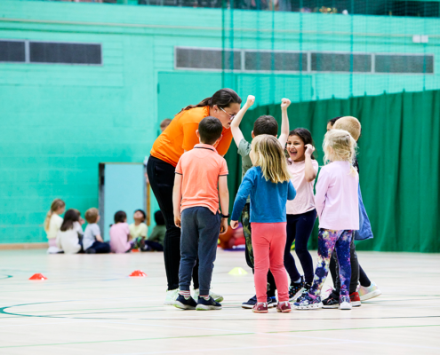 Leader with children on indoor pitch