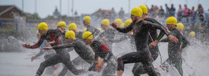 Triathletes running into the water