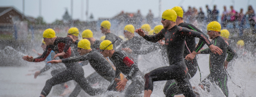 Triathletes running into the water
