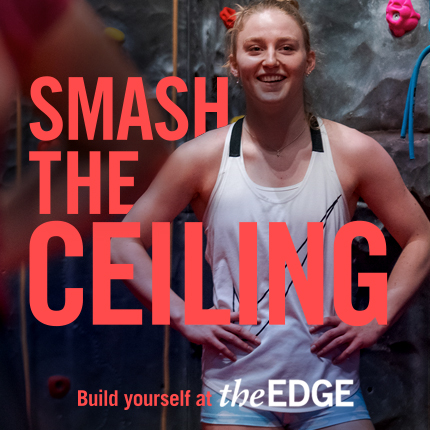 Girl looking accomplished standing by climbing wall. Text says: 'Smash the ceiling. Build yourself at The Edge'