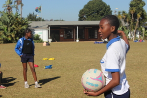 A girl holding a ball doing sports activities