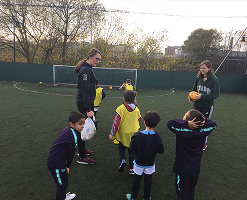 Community volunteers helping the children play football