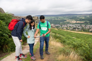 Three students looking at a map in scenic location