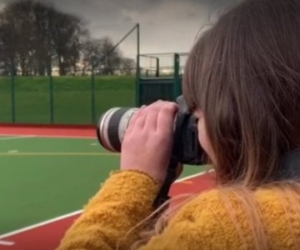 Female photographer with long lens camera