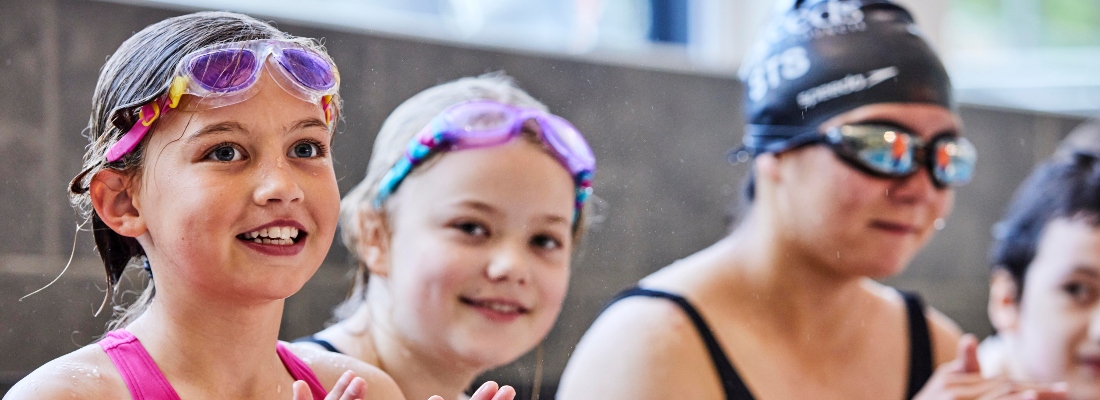 Girls on side of a swimming pool