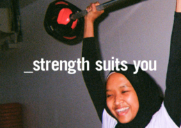 Young woman lifting barbell above her head